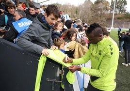 Sadiq firma una camiseta a un aficionado de la Real durante el entrenamiento de este jueves en Zubieta