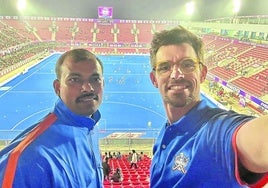 Ion Kamio, a la derecha con gafas, se hace un selfie con un compañero del staff en el estadio de hockey.