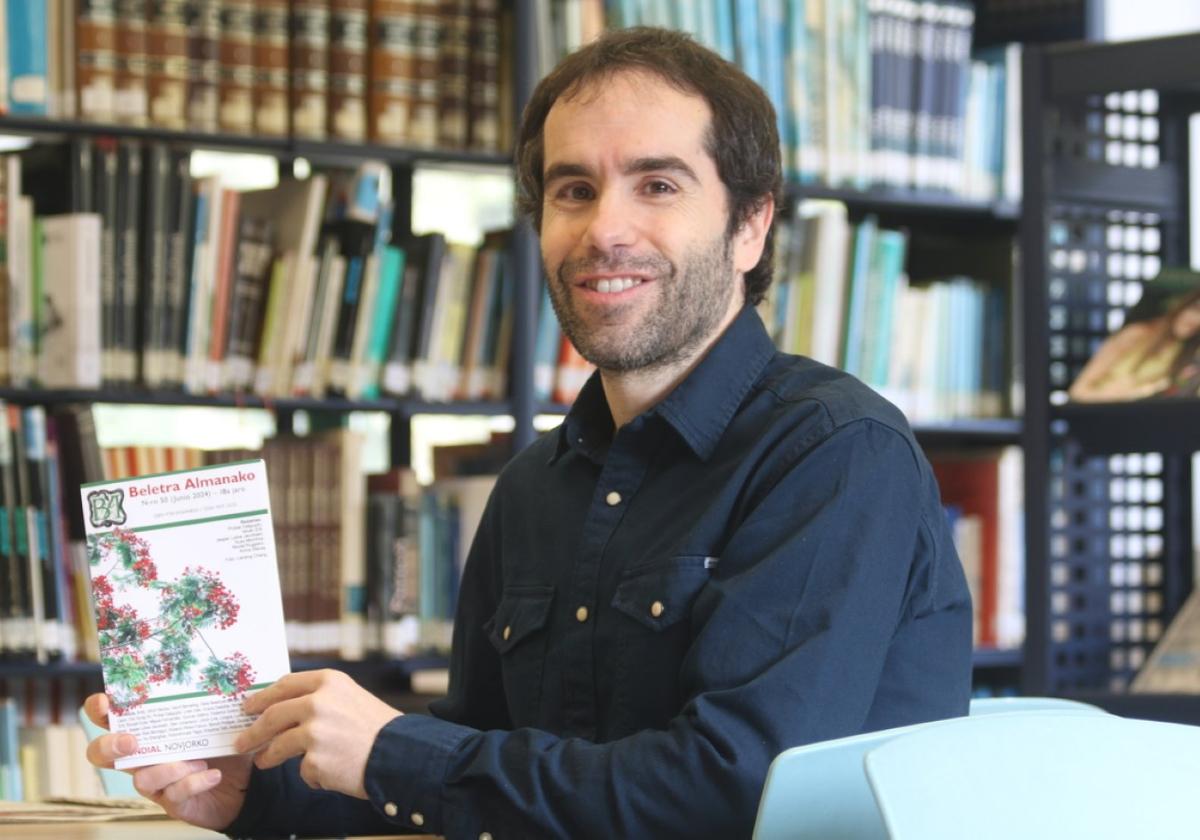 Iñaki Goitia posa con la revista 'Beletra Almanako' de Nueva York en la biblioteca, donde trabaja.