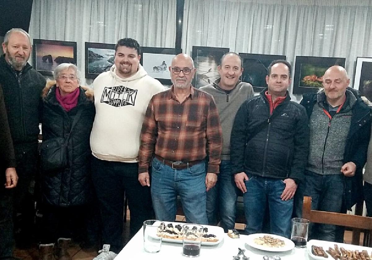 Algunos de los socios de Ortzadar que participan en la exposición, junto a varias de las fotografías el día de la inauguración.