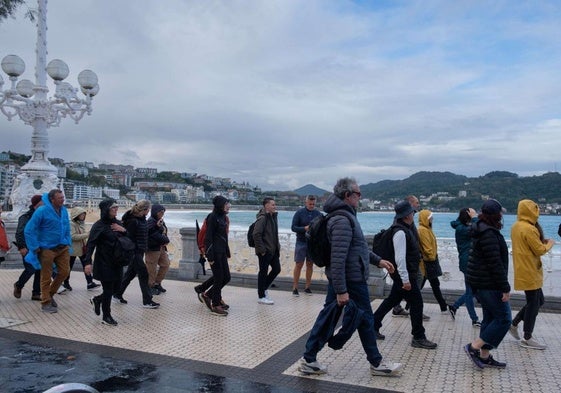 Un grupo de turistas camina por el paseo de La Concha.