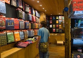 Un joven observa diferentes camisetas en la tienda de Kukuxumusu de San Sebastián en el año 2005.