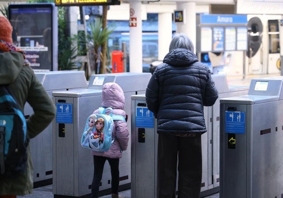 Una mujer accede este jueves a la estación del Topo de Donostia con una menor