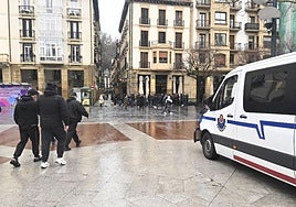 Un grupo de aficionados griegos pasa por delante de una furgoneta de la Ertzaintza ayer en el Boulevard