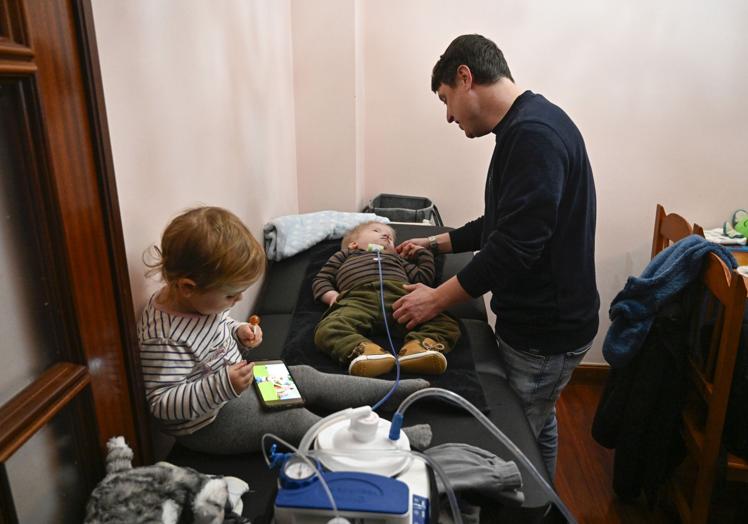 Thomas cuida a Milo mientras Aila se entretiene con una tablet.