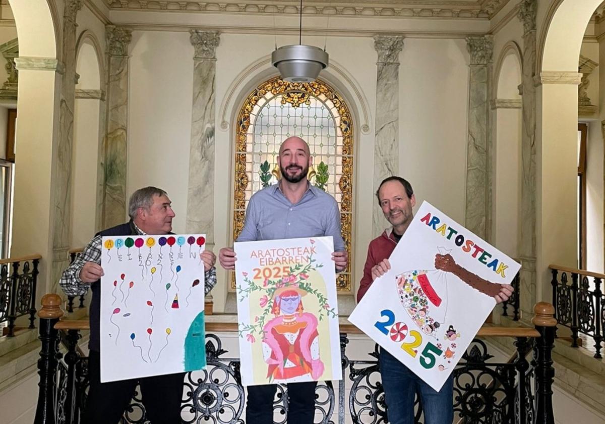 Patxi Lejardi, Jon Iraola y Asier López de Viñaspre, con los carteles ganadores del concurso de fiestas.