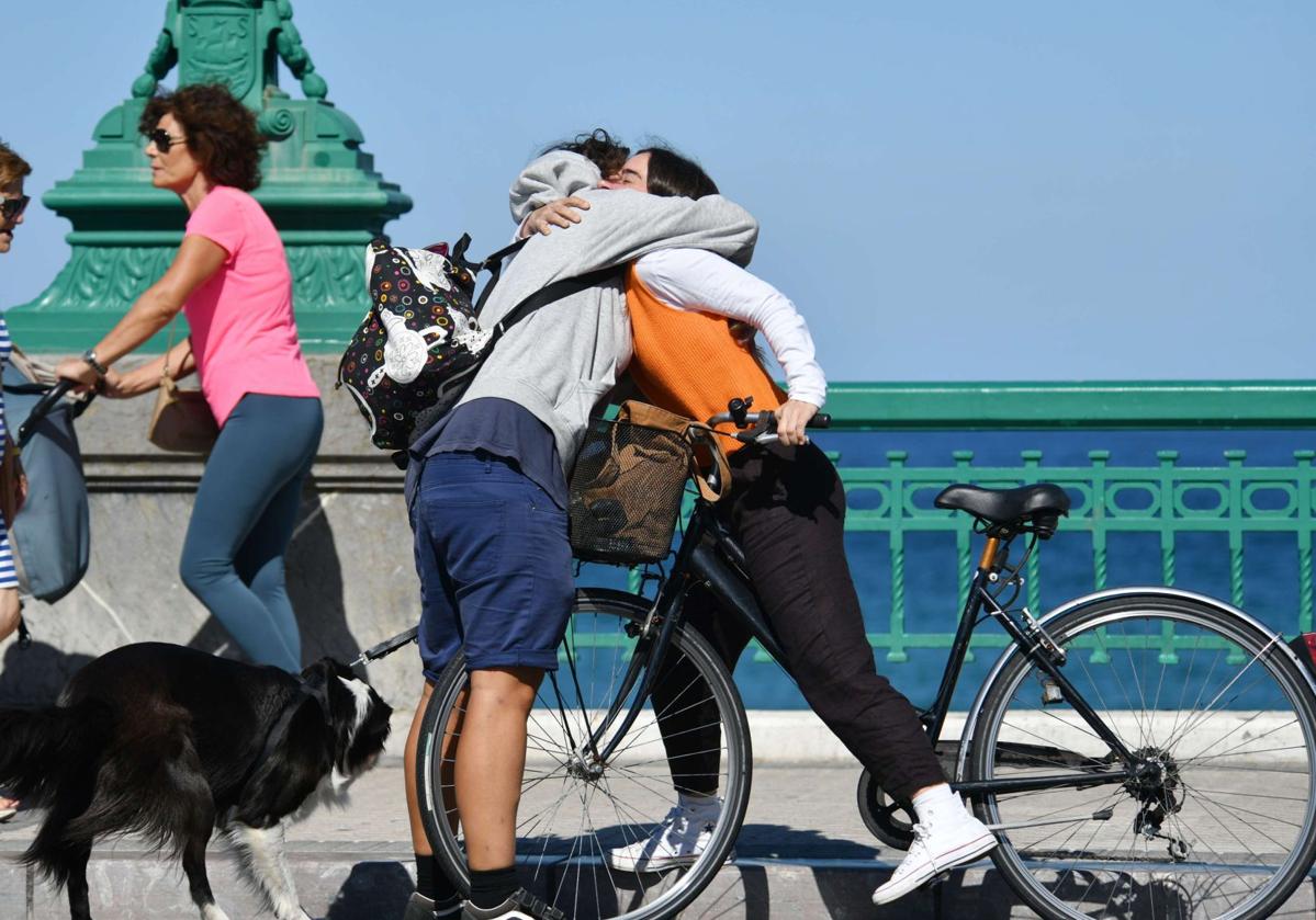 Dos personas se abrazan en el puente del Kursaal en Donostia.