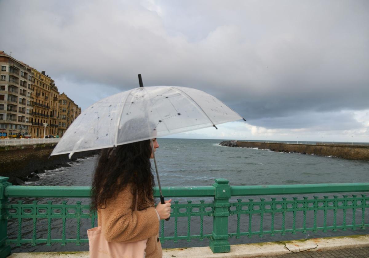 Una mujer con paraguas, ayer en San Sebastián.