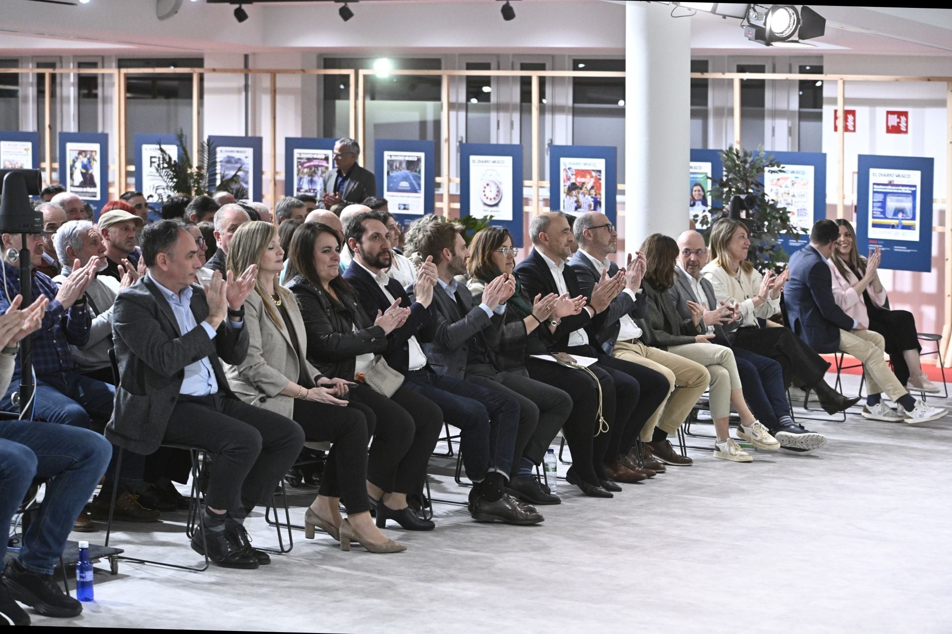 Público, autoridades y organizadores aplauden en un momento de la charla