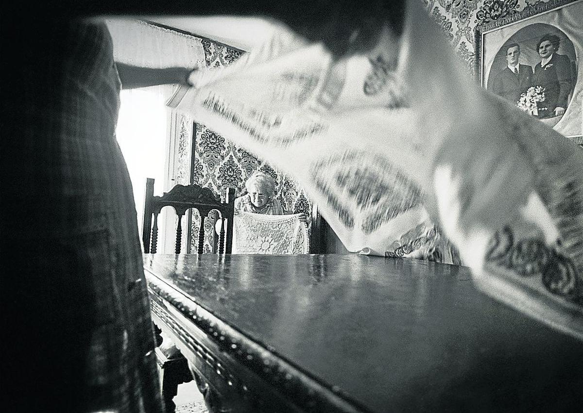 Imagen secundaria 1 - Arriba: Pako Bastida Azpiazu y Julieta Zubizarreta Albizu despiezando una oveja en la cocina del caserío Katalotza. Abajo, izquierda: María Arrizabalaga en una imagen cotidiana, en el caserío Urrategi.. Abajo, derecha: El autor, fotografiándose a sí mismo a través de un espejo. 