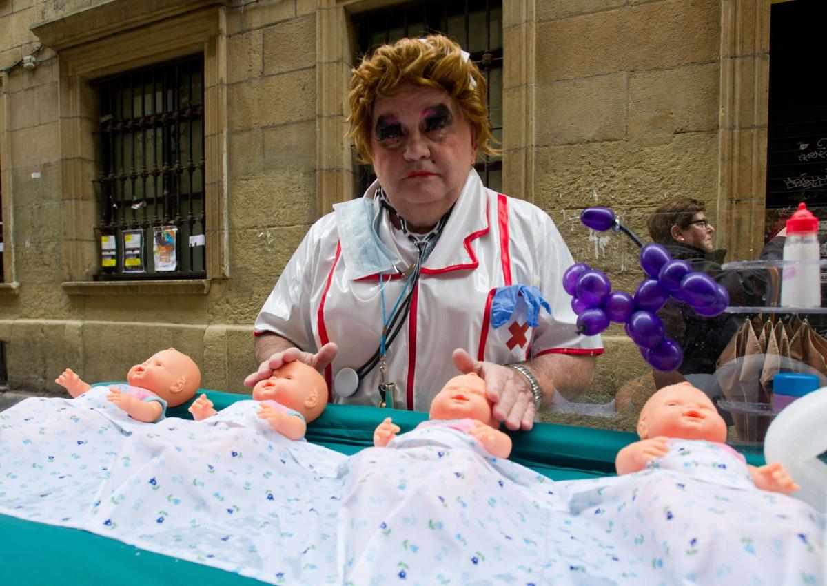 Imagen secundaria 1 - 'Bebés' hawaianos en la calle Elkano en 2004 y dos históricos de la fanfare: Carlos de Andrés y Manolo García, como Dios Momo en el año 2017.