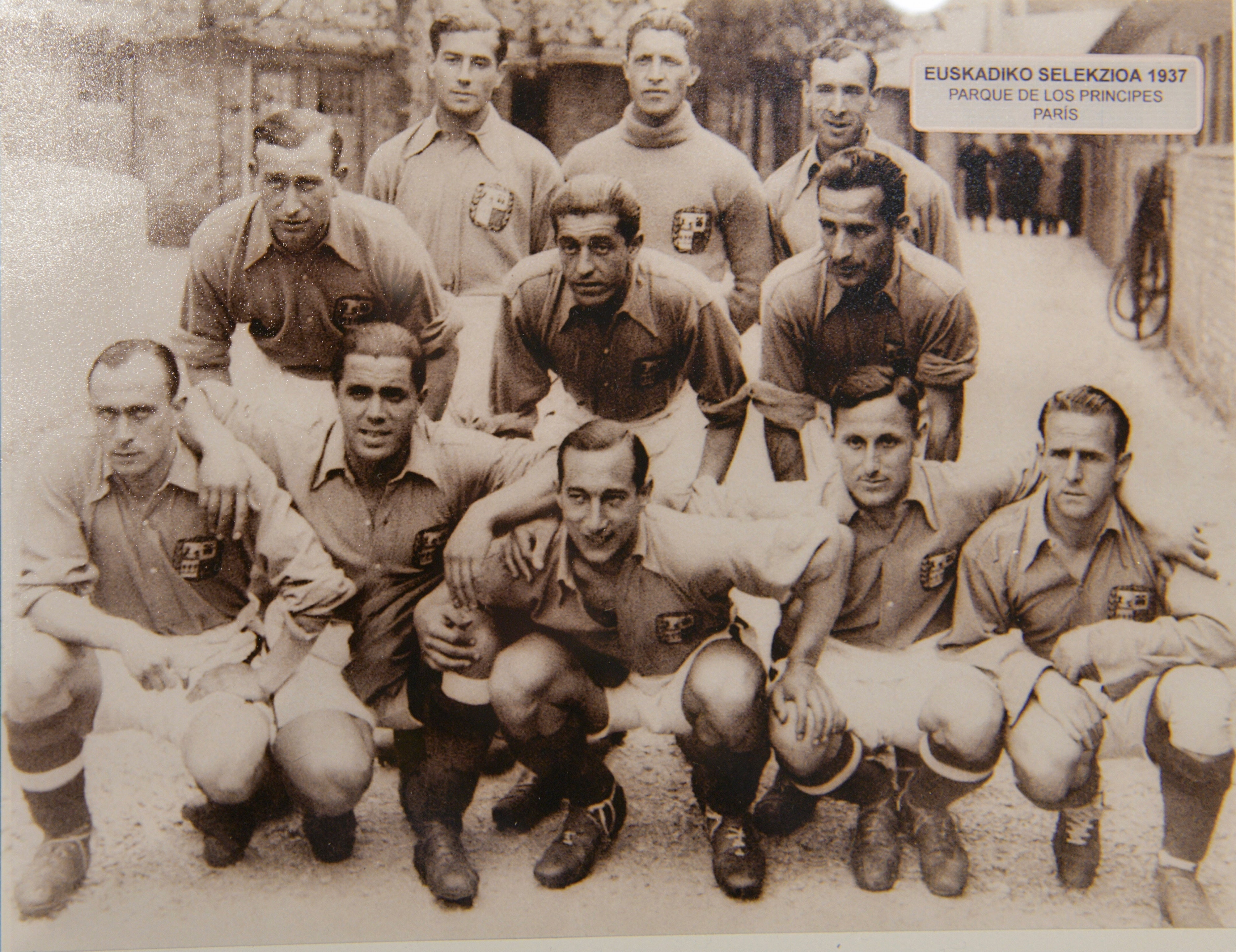 Imagen principal - Lángara, agachado justo en medio, con la selección de Euzkadi. Una imagen de sus botas y el contrato que firmó con el Oviedo.