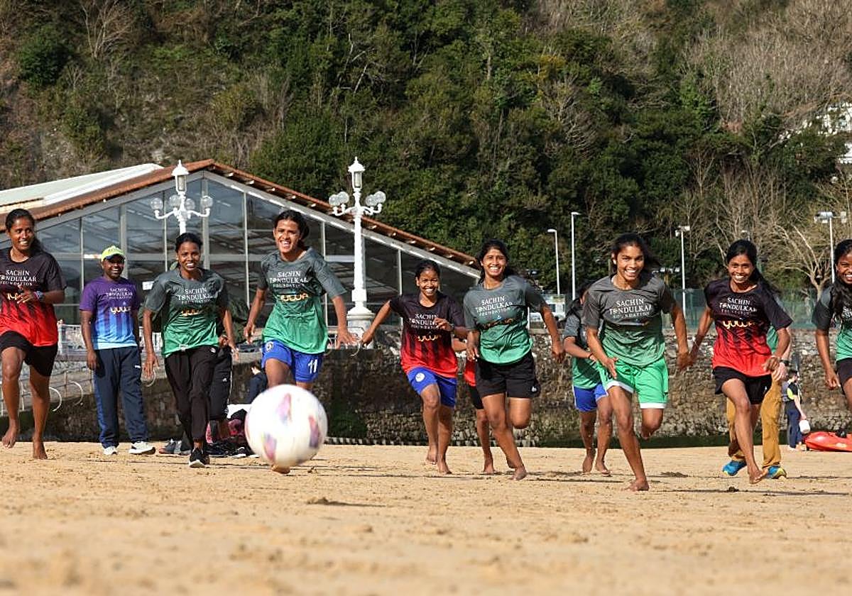 Las niñas de Yuwa juegan a fútbolen la playa de Ondarreta.