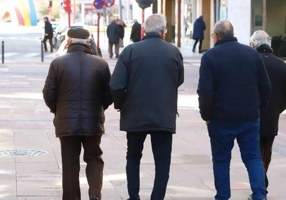 Cuatro jubilados pasean por la calle.