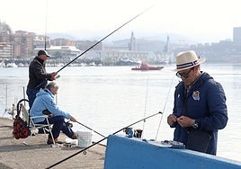 Varios pescadores preparan los cebos para tirar la caña en el muelle de San Pedro, junto a la lonja.