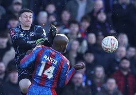 El portero del Millwall Liam Roberts golpea con los tacos de su bota la cabeza de Mateta.