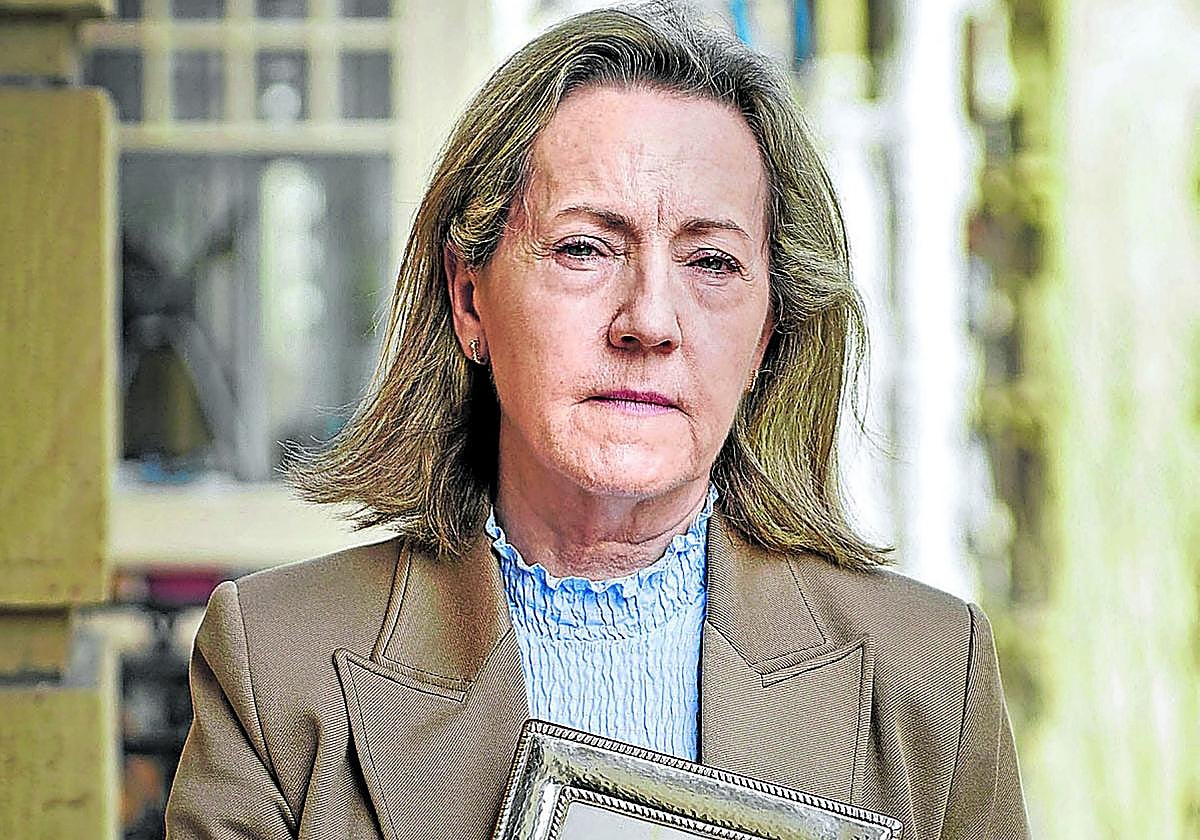 Teresa Díaz Bada posa en la terraza de su consulta de San Sebastián con un retrato de su padre.