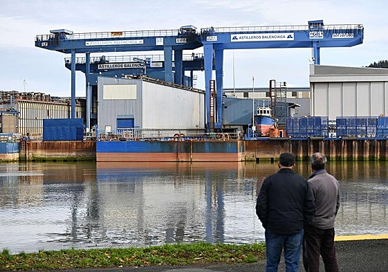 Dos personas observan las instalaciones de Astilleros Balenciaga, en Zumaia.
