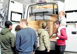 Varios visitantes se interesan por un modelo expuesto.