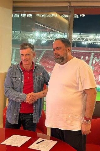 Mendilibar estrecha la mano del presidente Evangelos Marinakis tras firmar su renovación