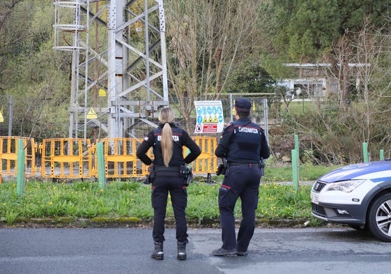 Ertzainas observan el vallado colocado en la base de la torre en la que se electrocutó un niño en Usurbil.