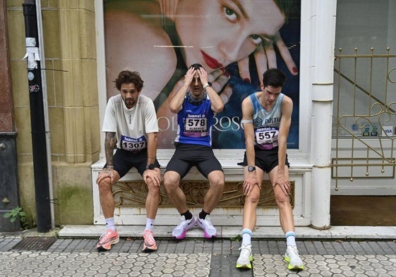 Tres corredores, exhaustos tras pasar la meta en la Behobia del año pasado.