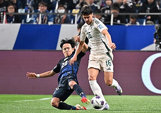 Take Kubo trata de arrebatar el cuero al jugador de Arabia Saudí Faisal Alghamdi