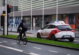 Un coche de autoescuela circula por delante del Kursaal donostiarra.