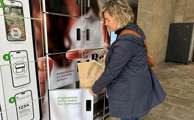 Leire Arandia recoge los productos adquiridos en el mercado del interior de una de las taquillas inteligentes.