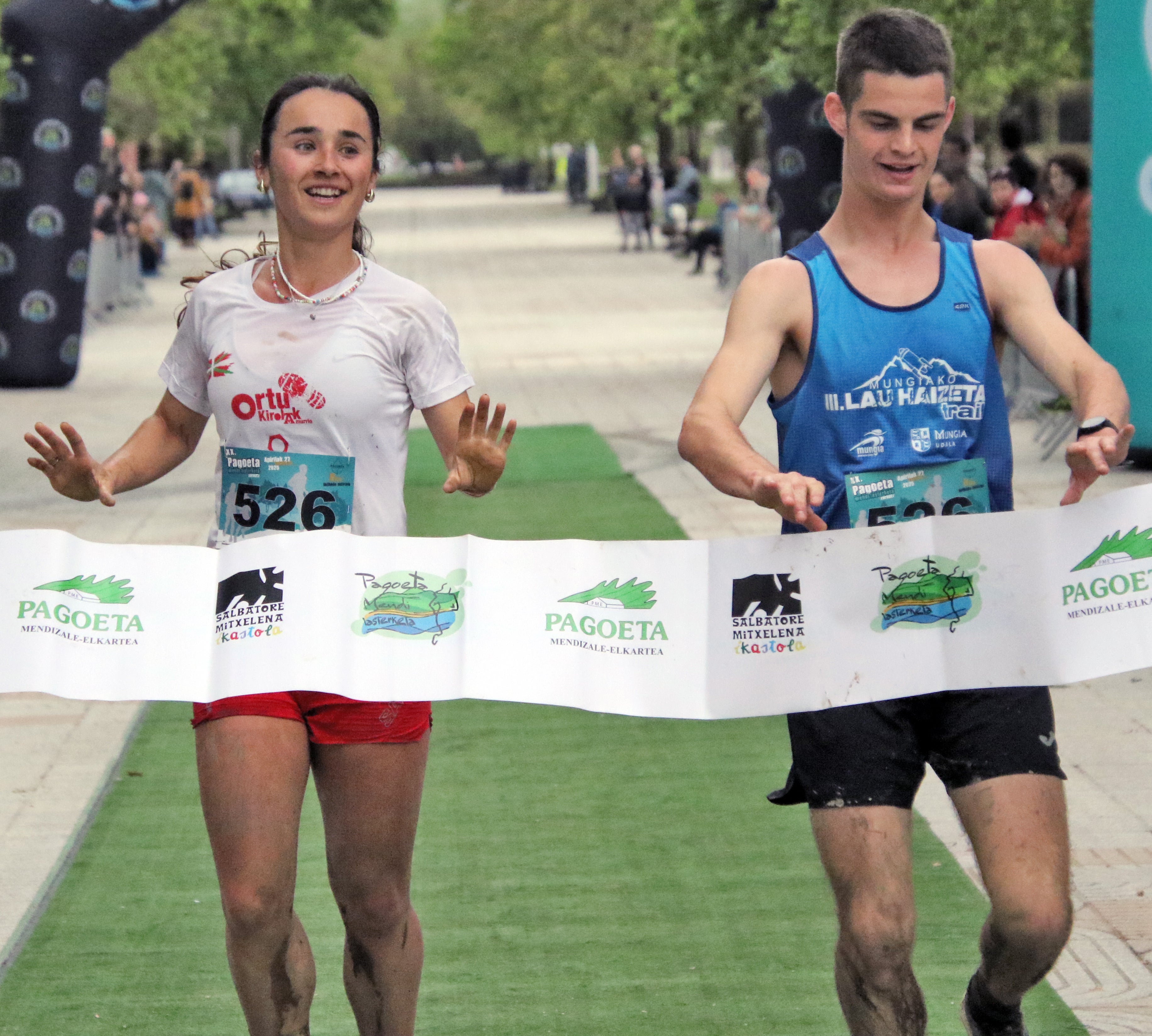 Imagen secundaria 1 - Natalia Navascues (3ª), Iratxe Aranburu (ganadora) y Amagoia Iribar (2ª) tras cruzar la llegada. La primera pareja, Eneritz Aramendi y Pello Ziarsolo. Amets Aranberri devolviendo los aplausos al público.