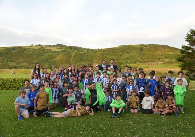 Remiro posa junto a muchos niños y niñas con quienes colabora en sus talleres.