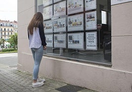 Una joven observa el escaparate de una inmobiliaria de Irun.