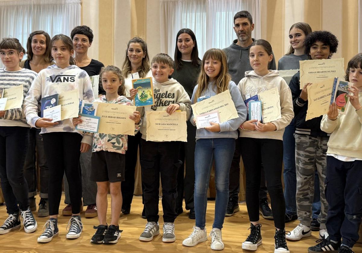 Literatur Lehiaketako sarituak udaletxeko batzar aretoan pozik jasotako opariekin.