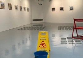 La señal de aviso de goteras acota un espacio de la sala.