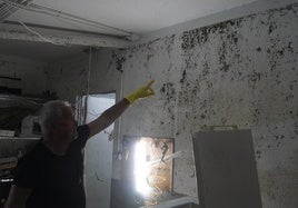 Un vecino señala la altura hasta la que llegó ayer el agua, prácticamente hasta el techo
