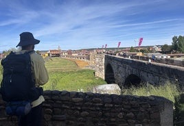 Un peregrino norteamericano observa el histórico paseo de Puente de Órbigo.