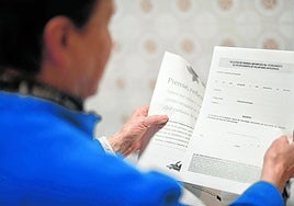 Una persona mayor sostiene entre sus manos una solicitud de inscripción del documento de voluntades anticipadas.