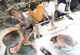 Algunos de los participantes del curso comentan los avances en la construcción de sus anguleras en miniatura.