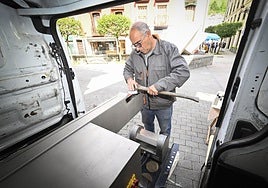 Jose Mari Albisu afila un hacha en la máquina instalada en el interior de su furgoneta en su puesto de la Feria de Ordizia.