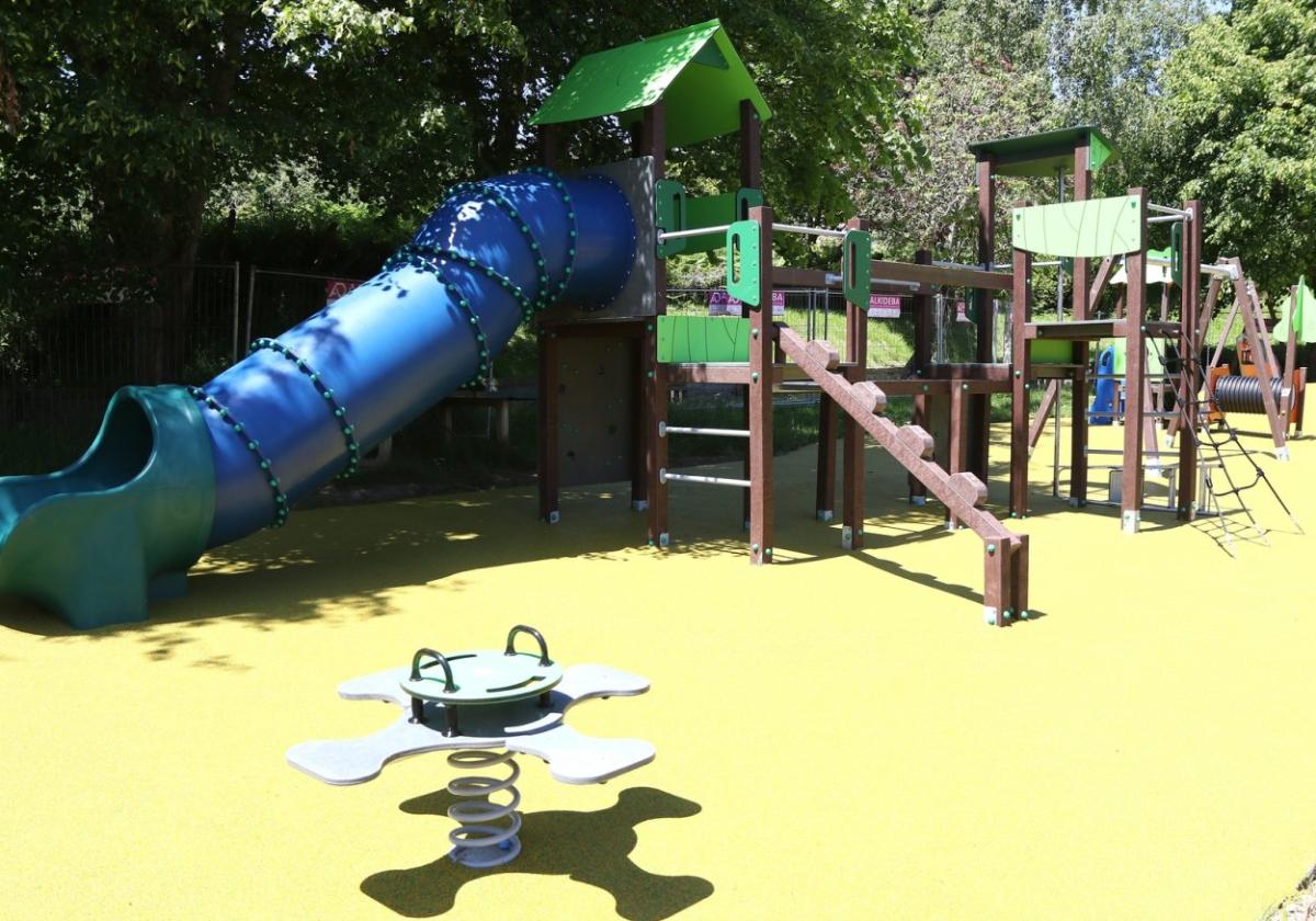 Vista de los nuevos juegos infantiles del parque, con el tobogán con forma de tubo en primer término.