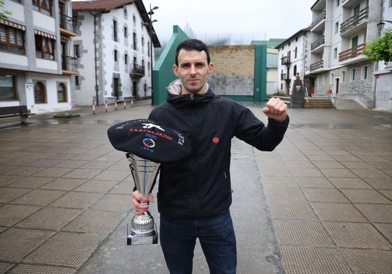 Jokin Altuna, en Amezketa, alza el puño en señal de victoria mientras sujeta el trofeo y la txapela que le acreditan como campeón.