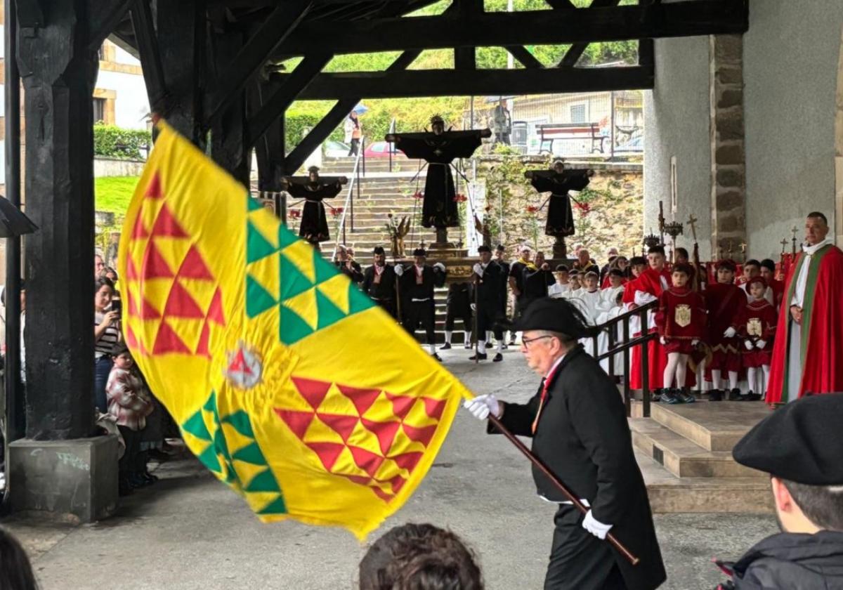 El abanderado, los dantzaris y los Santos, en los pórticos de la parroquia.