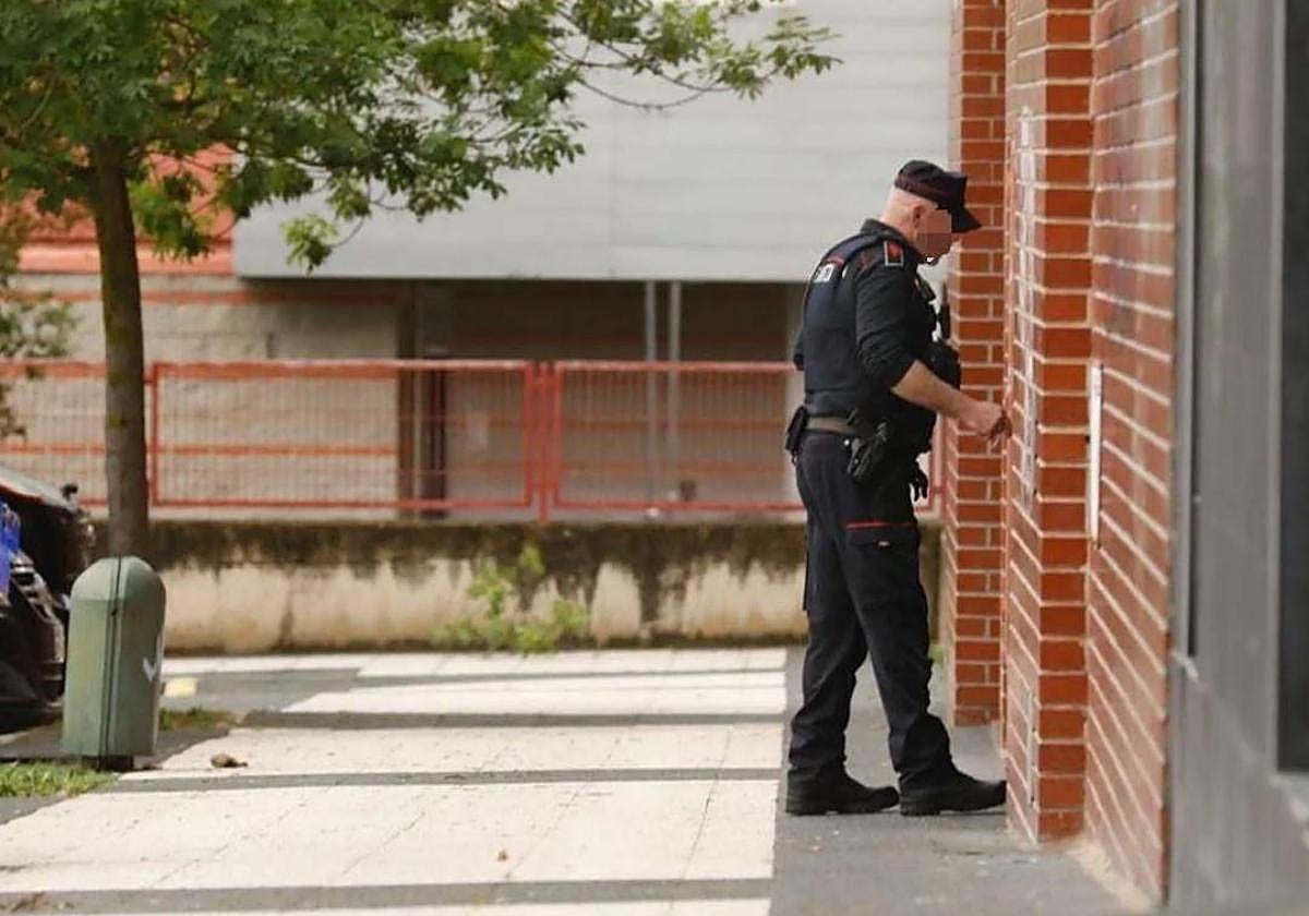 Un ertzaina accede a uno de los pisos de Vitoria donde se ha producido la operación.