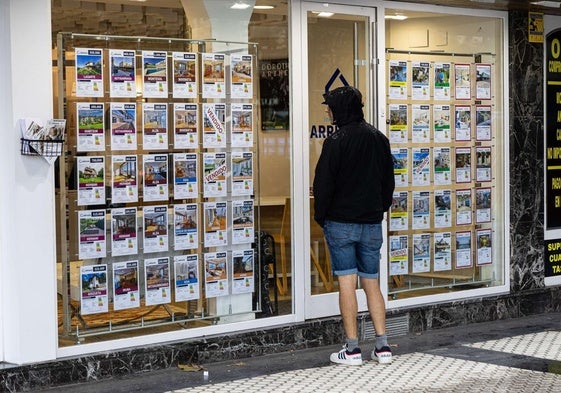 Un joven mira los anuncios en el escaparate de una inmobiliaria de Donostia.