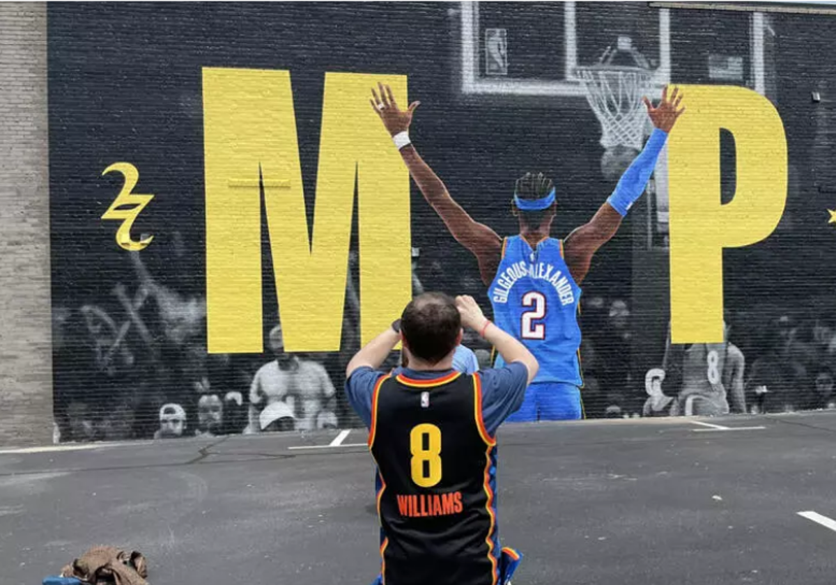 Un aficionado de los Thunder fotografía el mural de la estrella del equipo, Shai Gilgeous-Alexander, en Oklahoma City.