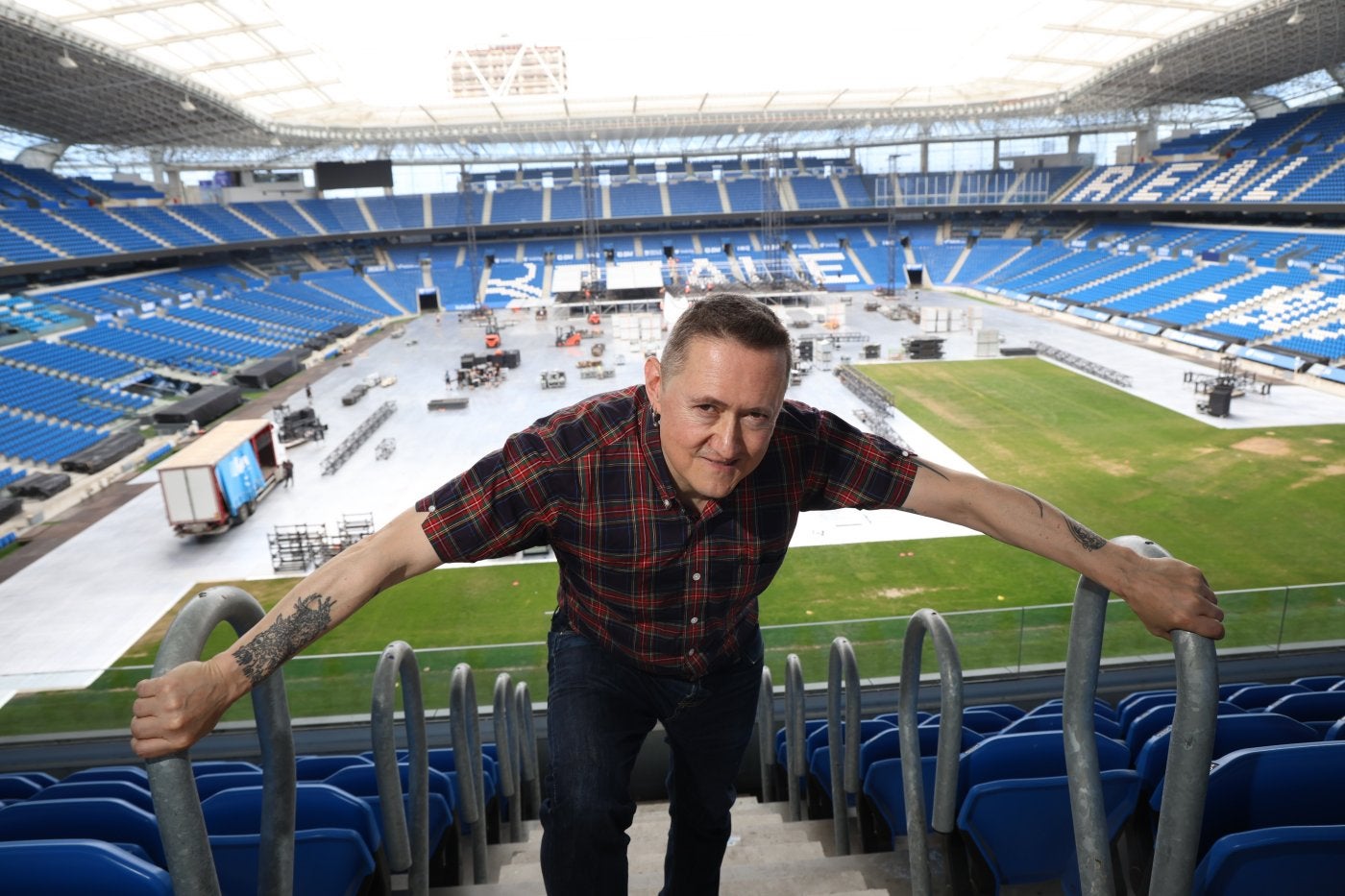 Fermin Muguruza, en las gradas de Anoeta con los preparativos para el concierto del sábado al fondo.