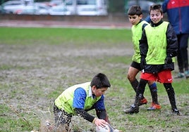 Tres niños juegna a rugby en Eibar.