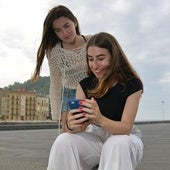 Maddi Garate, estudiante que ha sacado la mejor nota de Selectividad de Euskadi, consulta su calificación en el teléfono móvil bajo la mirada de una amiga este miércoles en San Sebastián.