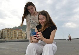 Maddi Garate, estudiante que ha sacado la mejor nota de Selectividad de Euskadi, consulta su calificación en el teléfono móvil bajo la mirada de una amiga Alaine este miércoles en San Sebastián.