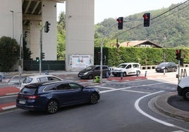 Vehículos parados en el nuevo paso peatonal de Usatorre, con un operario terminando la puesta a punto.